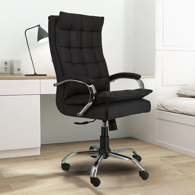Black office chair in a modern room with a desk and lamp.
